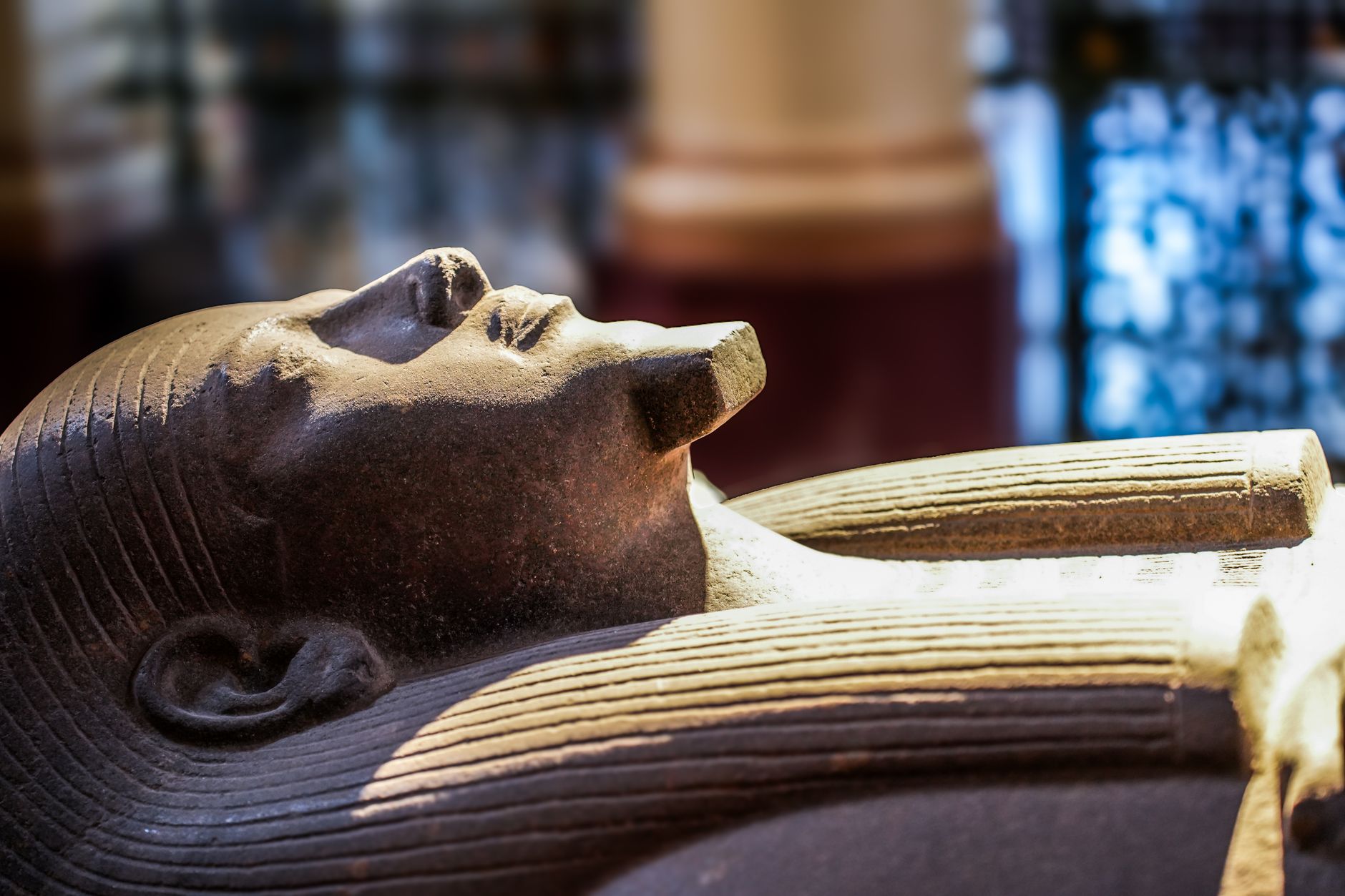Gros plan d'un sarcophage égyptien ancien exposé dans un musée, présentant des détails complexes.