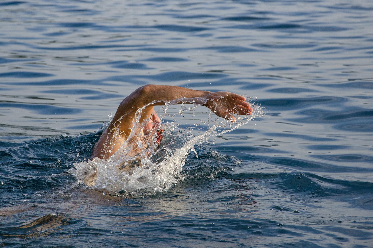 Un nageur en crawl fend l’eau d’une mer bleue